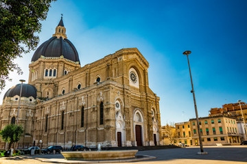 Fototapeta premium Cathedral of San Pietro Apostolo, also known as Duomo Tonti, by Paolo Tonti, who donated his wealth for its construction. Facade, rose windows, portals, dome and fountain. Cerignola, Puglia, Italy.