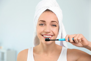 Portrait of young woman with toothbrush on blurred background