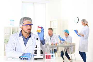 Male scientist working at table in laboratory, space for text. Research and analysis