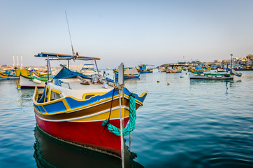 Fototapeta premium Traditional eyed colorful boats Luzzu in the Harbor of Mediterranean fishing village Marsaxlokk, Malta