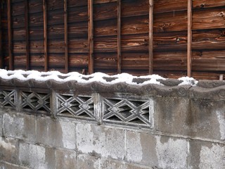 古民家と雪の積もった塀