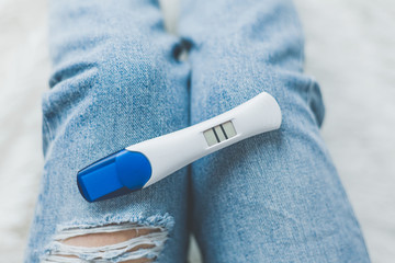 Woman looking on positive pregancy test