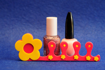 Nail polish and a toe separator on a blue background