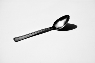 silver spoon on pale white background - monochrome