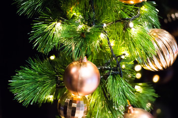 Closeup decorated christmas branch with led light. Golden ball bauble and other ornaments hang on the christmas branch tree. Merry christmas and happy new year concept.