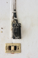 a light switch and electrical breaker switch with damaged wiring on the wall