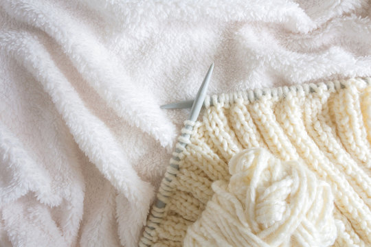 knitting white wool yarn pattern. Closeup horizontal photo. Freelance creative handicraft concept, hobby and lifestyle