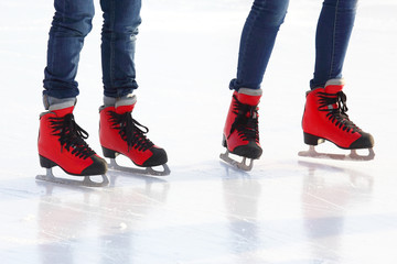 feet in red skates on an ice rink