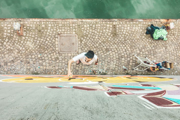 Top view of graffiti artist painting with color spray on the wall