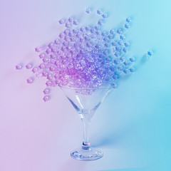 Martini glass with pink glitter in vibrant bold gradient holographic colors. Party drink concept art. Minimal New Year surrealism.