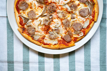 Fresh pizza with tomatoes, cheese and sausage