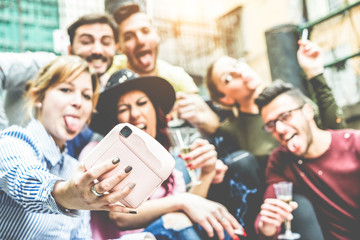 Group of millennials people taking selfie with instant camera at party outdoor - Focus on...