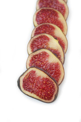 Fresh ripe fig slices in a row isolated on white background
