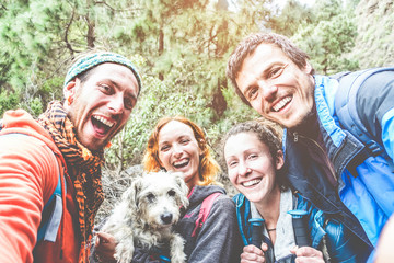 Happy trekkers people taking selfie for social network story with their dog