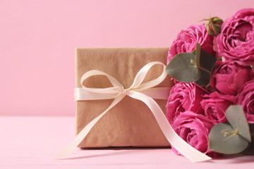 gift and flowers on a colored background. Holiday, give a gift, congratulations. Valentine's Day, Mother's Day, International Women's Day.