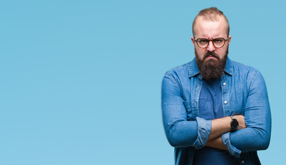Obraz premium Young caucasian hipster man wearing glasses over isolated background skeptic and nervous, disapproving expression on face with crossed arms. Negative person.