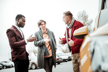 Father convincing his young sin to buy new orange car
