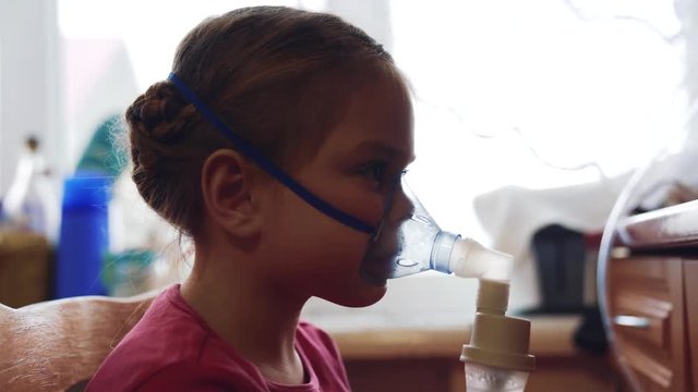 The procedure of inhalation of the child. Disease of the respiratory and respiratory tract. 4K video with shallow depth of field focus.