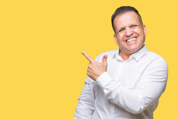 Middle age arab elegant man over isolated background cheerful with a smile of face pointing with hand and finger up to the side with happy and natural expression on face