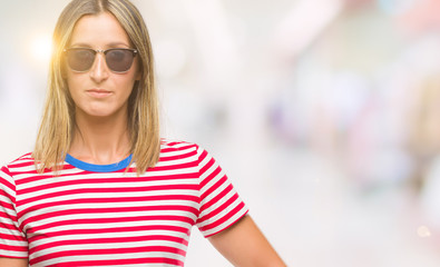 Young beautiful woman holding soccer football ball over isolated background with a confident expression on smart face thinking serious