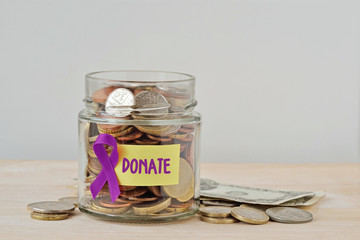 Money jar full of coins with violet ribbon and Donate label - Concept of Alzheimer, Pancreatic...