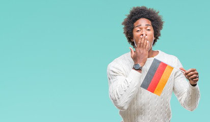 Afro american man flag of Germany over isolated background cover mouth with hand shocked with shame for mistake, expression of fear, scared in silence, secret concept