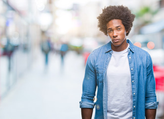 Afro american man over isolated background skeptic and nervous, frowning upset because of problem....