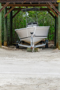 boat on a trailer stored under a conopy near the beach