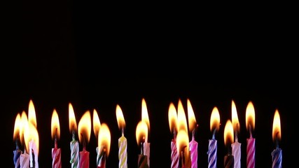 birthday candles light on isolated black