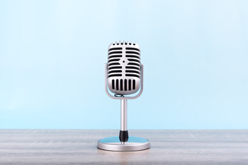 Microphone retro Put on wooden table isolated on blue background.