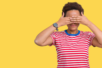 Beautiful young african american woman wearing glasses over isolated background smiling and laughing with hand on face covering eyes for surprise. Blind concept.