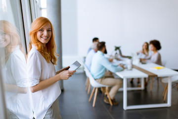 Pretty young red hair woman using digital tablet