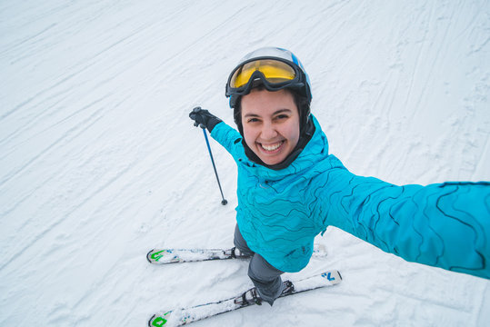 young pretty woman making selfie while skiing.