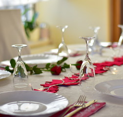 Place or table settings for party dinner or Valentine`s day or Christmas with red stars and red roses.