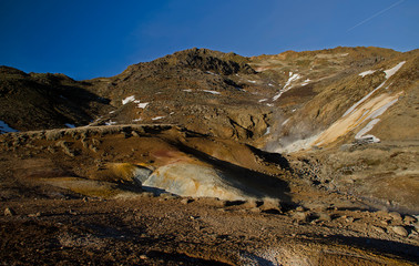 Fototapeta na wymiar Fumarole fields of Iceland covered with yellow brimstone with boiling mud craters against the winter sky