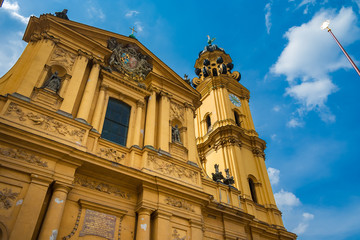 Fototapeta na wymiar Great low angle view of Munich's Theatine Church of St. Cajetan, a Catholic church in Italian high-Baroque style. Its Mediterranean appearance and yellow façade became a famous symbol for the city.
