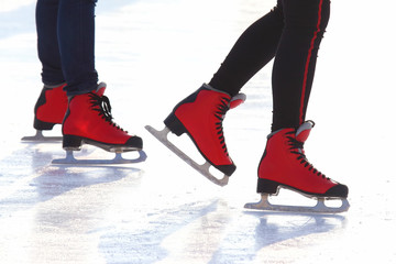 feet in red skates on an ice rink