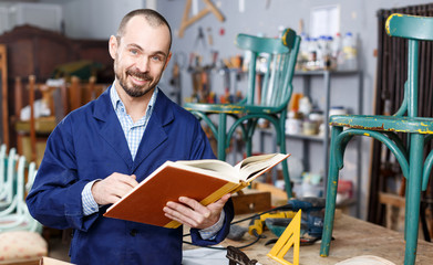 Craftsman looking at album in workshop