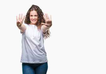 Obraz na płótnie Canvas Beautiful brunette curly hair young girl wearing casual t-shirt over isolated background showing and pointing up with fingers number nine while smiling confident and happy.