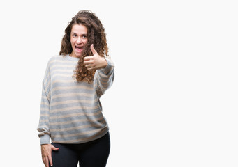 Beautiful brunette curly hair young girl wearing winter sweater over isolated background doing happy thumbs up gesture with hand. Approving expression looking at the camera with showing success.