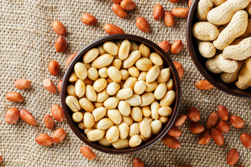 Peanuts in the shell and peeled closeup in a cup