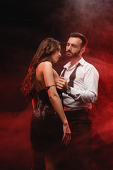 Fototapeta na wymiar seductive couple together in red smoky room