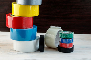 Several rolls of adhesive tape are stacked. stack of electrical tape stand nearby. have toning....