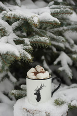 Drink with marshmallows in winter under the tree.