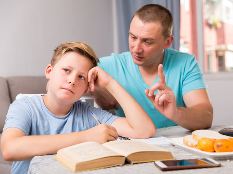 Man is offended and son is not wanting talking with him in time doing homework