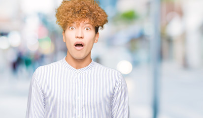 Young handsome business man with afro hair wearing elegant shirt afraid and shocked with surprise expression, fear and excited face.