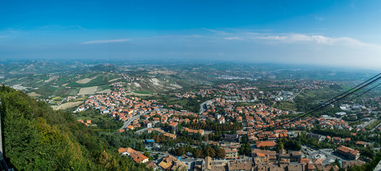 panoramic view on the hilly plain of the foothills of the Apennines with city and funicular cable way from the mountain  Monte Titano, old city of republic of san marino