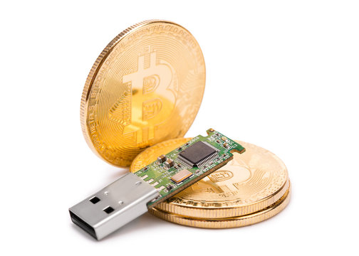 Cold crypto wallet on golden bitcoin coins.
