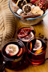 Fototapeta na wymiar glasses of mulled wine with dry citrus and spices ,knitted sweater.