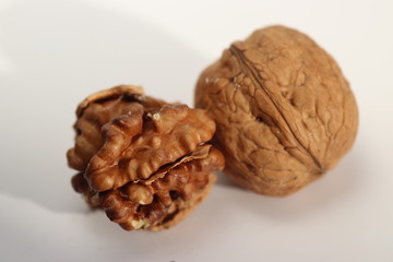 Shelled walnut in front of unshelled walnut